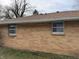 Exterior view of a brick home with multiple windows and a brown roof at 1632 W 7Th St, Anderson, IN 46016