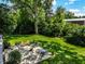 Elevated view of a spacious backyard with a stone patio, lush greenery, and seating at 6463 N Illinois N St, Indianapolis, IN 46260