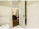 Subtle bathroom with toilet and view of bedroom with striped walls at 6463 N Illinois N St, Indianapolis, IN 46260