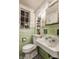 Retro bathroom with green tile, vintage sink, and floral wallpaper at 6463 N Illinois N St, Indianapolis, IN 46260