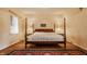 Bedroom with four-poster bed, hardwood floors, and window with blinds at 6463 N Illinois N St, Indianapolis, IN 46260