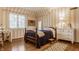 Cozy bedroom with striped walls, hardwood floors, and antique furniture at 6463 N Illinois N St, Indianapolis, IN 46260