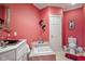 Bathroom with coral walls, pedestal sink, and toilet at 8292 S State Road 39 S Rd, Clayton, IN 46118