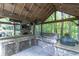Covered outdoor kitchen with granite countertops, grill, and ample seating at 2705 S 975 E, Zionsville, IN 46077