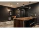 Finished basement with a bar area, seating, and dark walls at 8235 Ridge Valley Ct, Indianapolis, IN 46278
