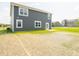 Gray house exterior with backyard patio and grassy area; other homes visible in the background at 5714 Cattail Branch Ln, Clayton, IN 46118