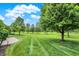 Landscaped backyard with lush lawn and trees at 15482 Bridgewater Club Blvd, Carmel, IN 46033