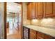 Butlers pantry with granite countertop, wood cabinets, and wine cooler at 15482 Bridgewater Club Blvd, Carmel, IN 46033