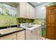 Laundry room with painted mural, washer, dryer, and cabinets at 15482 Bridgewater Club Blvd, Carmel, IN 46033