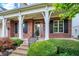 Covered front porch with brick columns and black shutters at 15482 Bridgewater Club Blvd, Carmel, IN 46033