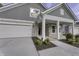 Gray house exterior with stone accents, white garage door, and landscaping at 11451 Neptune Dr, Fishers, IN 46040