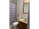 Bathroom with toilet, sink, shower, and patterned curtain at 6820 Hi Vu Dr, Indianapolis, IN 46227