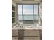 Bathroom with a large soaking tub and a window offering city views at 1 N Illinois St # 2101, Indianapolis, IN 46204