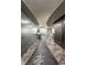 Unique curved hallway with grey metallic walls and stone flooring at 1 N Illinois St # 2101, Indianapolis, IN 46204