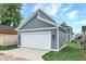 Detached gray garage with white door and walkway at 220 Sanders St, Indianapolis, IN 46225