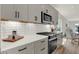 Modern kitchen with gray cabinets, white backsplash, and stainless steel appliances at 220 Sanders St, Indianapolis, IN 46225