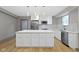 Modern kitchen with white cabinets, large island, and stainless steel appliances at 4513 Norwaldo Ave, Indianapolis, IN 46205