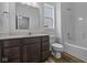Clean bathroom with dark brown vanity, a bathtub and a window at 10628 Maidenhair Dr, Indianapolis, IN 46239