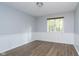 Bedroom with wood-look flooring, window and wainscoting at 6235 Johnson Rd, Indianapolis, IN 46220