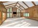 Spacious living room with vaulted ceiling, fireplace, and large windows at 6235 Johnson Rd, Indianapolis, IN 46220