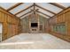 Vaulted ceiling living room with brick fireplace and wood paneling at 6235 Johnson Rd, Indianapolis, IN 46220