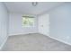 Spacious bedroom with grey carpet and a large window at 6235 Johnson Rd, Indianapolis, IN 46220