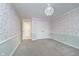 Bedroom with floral wallpaper, grey carpet, and double doors at 6235 Johnson Rd, Indianapolis, IN 46220
