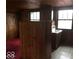 Upper level features a small room with wood paneling, a sink, and window at 3358 Ruckle St, Indianapolis, IN 46205