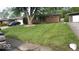 Brick ranch home with a tree, lawn, and driveway at 4013 N Audubon Rd, Indianapolis, IN 46226
