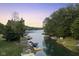 Aerial view of lakefront property with boats and lush trees at sunset at 5181 S Poplar Dr, Columbus, IN 47201