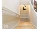 Wooden staircase leading to lower level, decorated with lighthouse wall art at 5181 S Poplar Dr, Columbus, IN 47201