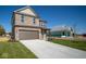 Two-story brick home with brown garage door, next to a house under construction at 1402 Foxtail Ln, Greenwood, IN 46143
