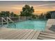 Inviting inground pool with wooden deck and sunset view at 5647 W Mooresville Rd, Indianapolis, IN 46221