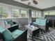 Spacious enclosed porch featuring comfortable seating and a ceiling fan at 5647 W Mooresville Rd, Indianapolis, IN 46221