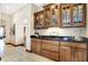 Wet bar with dark wood cabinetry, granite countertop, and glass-front cabinets at 9088 Nautical Watch Dr, Indianapolis, IN 46236