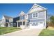 Two-story home with a blue exterior, two-car garage and landscaping at 1678 Orchard Dr, Fortville, IN 46040