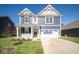 Two-story home with a blue exterior, two-car garage and landscaping at 1678 Orchard Dr, Fortville, IN 46040