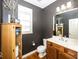 Powder room with dark gray walls, wood vanity, and hardwood floor at 13094 Overview Dr # 5D, Fishers, IN 46037