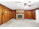 Living room with brick fireplace, wood paneling, and ceiling fan at 70 Cossell Dr, Indianapolis, IN 46224