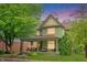 Charming two-story green house with a wrap-around porch and well-manicured lawn at 302 S Walnut St, Edinburgh, IN 46124