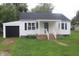 White house with black garage door and porch at 2312 E 22Nd St, Muncie, IN 47302
