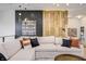 Open living area with sectional sofa and a feature wood wall at 9760 Windy Hills Dr, Zionsville, IN 46077