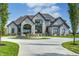 Stunning stone and metal exterior with a circular driveway at 9760 Windy Hills Dr, Zionsville, IN 46077