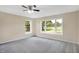 Spacious bedroom with grey carpet and large windows offering a view of the backyard at 10614 N 300 E, Morristown, IN 46161