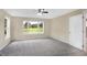 Bright bedroom with grey carpet, large windows, and a view of a green field at 10614 N 300 E, Morristown, IN 46161