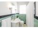 Retro bathroom with mint green tile, shower, and white vanity at 1683 Conner St, Noblesville, IN 46060