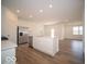 Modern kitchen with white cabinets, an island, stainless steel appliances, and wood-style flooring at 5660 Cattail Branch Ln, Clayton, IN 46118