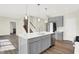 Open concept kitchen with gray cabinets, island, and stainless steel appliances at 19663 Atwater Ave, Sheridan, IN 46069