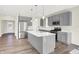 Modern kitchen with gray cabinets, island, stainless steel appliances, and hardwood floors at 19663 Atwater Ave, Sheridan, IN 46069