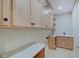 Bright laundry room with shaker cabinets and granite countertops at 3621 Olive Branch Rd, Greenwood, IN 46143